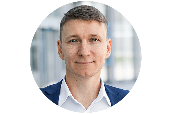 Headshot of Anton Cherevko, smiling into the camera, in front of a building